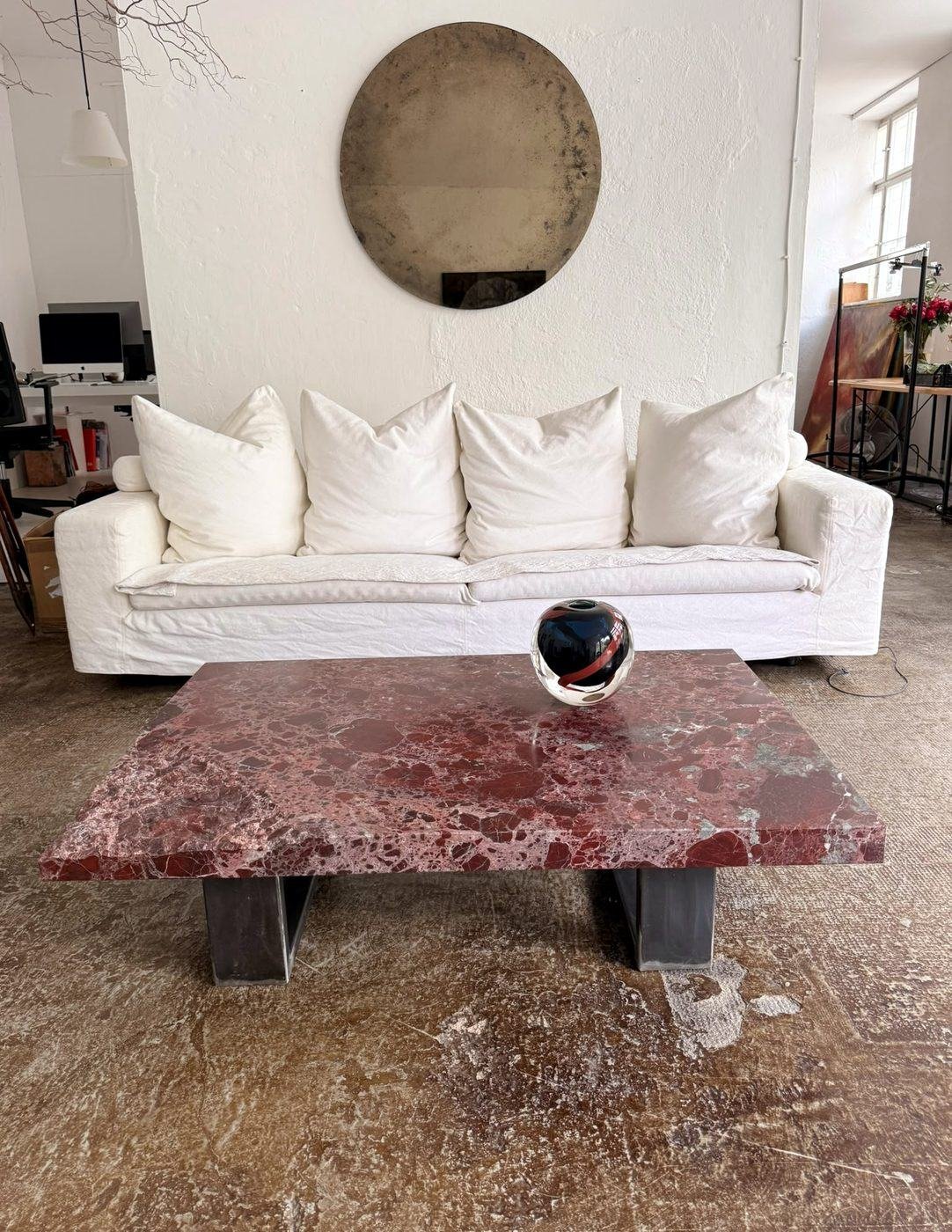 Rosso Lepanto marble coffee table on dark steel legs in a living room, made by Studio Giannoni, Pietrasanta