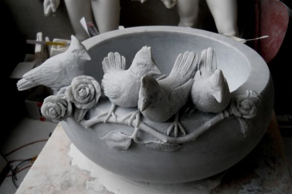 Hand-carved marble bird bath bowl decorated with birds and roses in Pietrasanta